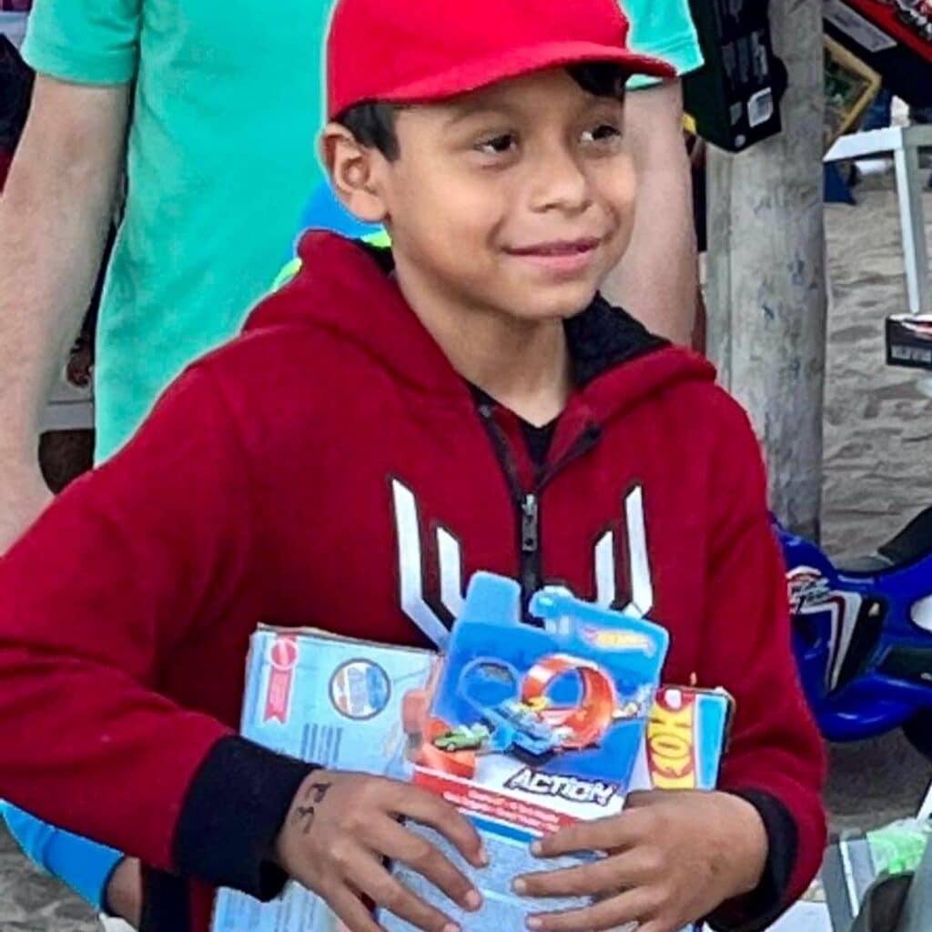 Una antigua tradición continuó esta mañana de Navidad en la playa, frente al bar, restaurante y hotel Blue Chairs. John Ramsey captó estas sonrisas de felicidad cuando los niños pudieron elegir un regalo de Navidad colgado de las palmeras.
