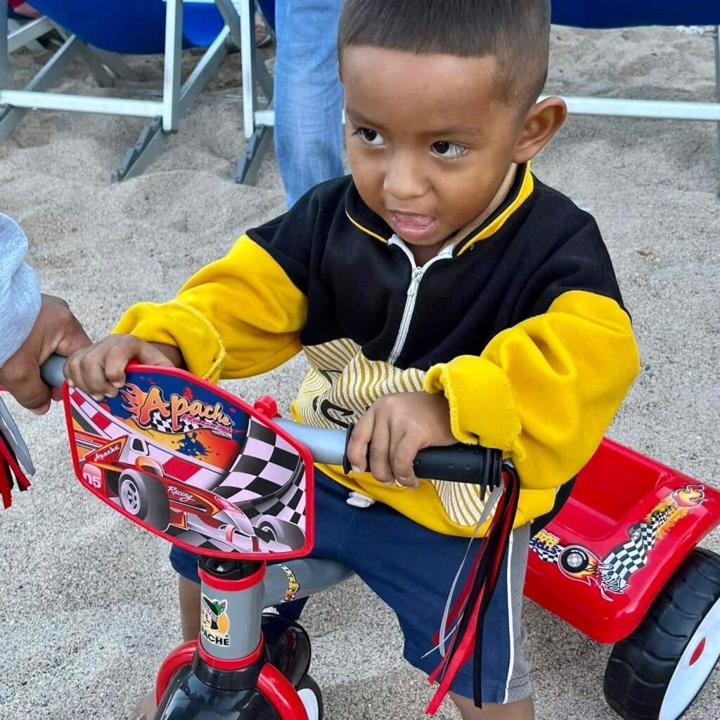 Una antigua tradición continuó esta mañana de Navidad en la playa, frente al bar, restaurante y hotel Blue Chairs. John Ramsey captó estas sonrisas de felicidad cuando los niños pudieron elegir un regalo de Navidad colgado de las palmeras.