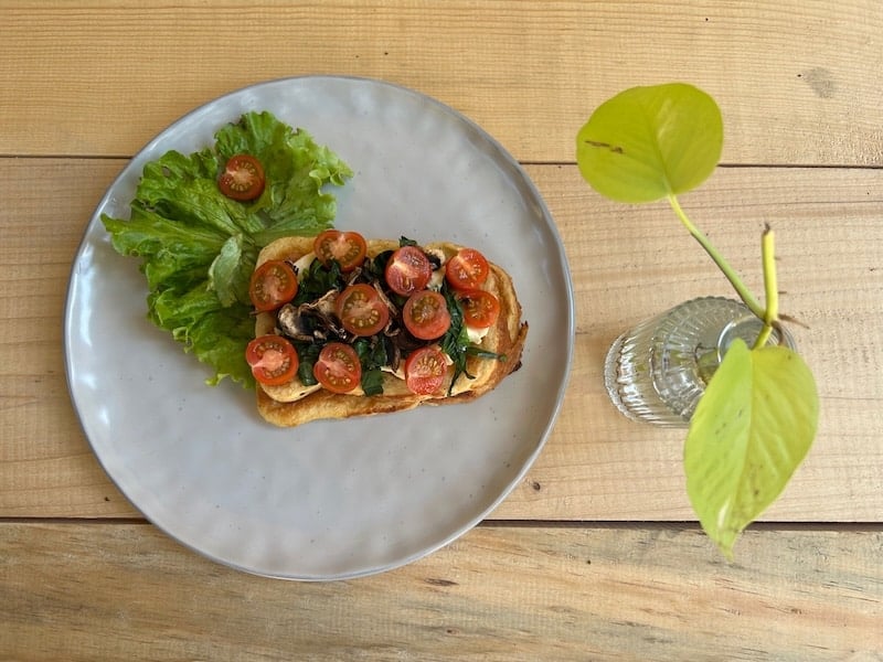 Tostada Lulú del Campo: Queso crema con champiñones, espinacas y tomates cherry.