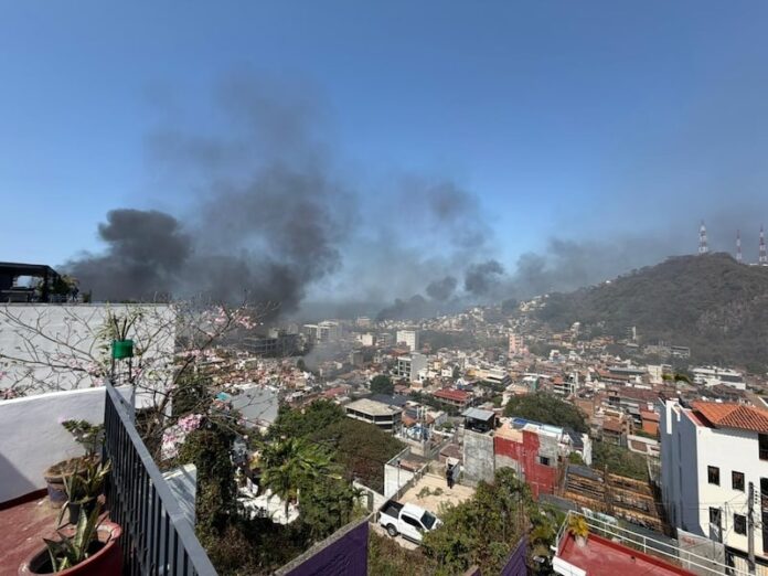 Incendios de vehículos y negocios estallaron en múltiples barrios de Puerto Vallarta el domingo por la mañana, lo que llevó a las autoridades a activar una alerta de seguridad de Código Rojo e instar a los residentes a permanecer en sus casas mientras la violencia se extendía por partes del oeste de México.