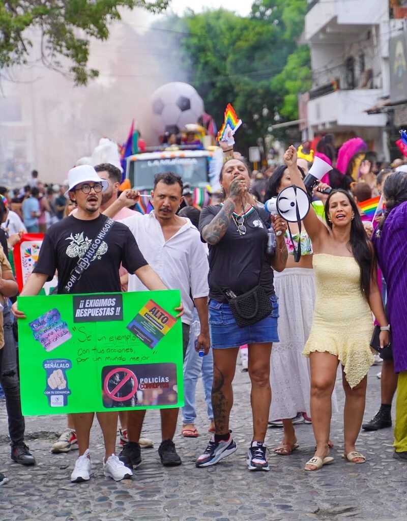 Juan Manuel López (izquierda) alzando su voz en apoyo de su causa durante Vallarta Pride 2026, junto a activistas como Kenya Cuevas y la regidora local Melissa Madero.