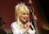 Dolly Parton, icono de la música country y querida defensora de la comunidad LGBTQ+, fallece a los 80 años La estrella del country Dolly Parton canta en el escenario durante una retransmisión en directo del Grand Ole Opry en Nashville, Tennessee, el 23 de abril de 2005, mientras unos soldados estadounidenses ven el espectáculo a través de una retransmisión en vídeo en Irak. Foto de Wikimedia Commons.