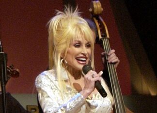 Dolly Parton, icono de la música country y querida defensora de la comunidad LGBTQ+, fallece a los 80 años La estrella del country Dolly Parton canta en el escenario durante una retransmisión en directo del Grand Ole Opry en Nashville, Tennessee, el 23 de abril de 2005, mientras unos soldados estadounidenses ven el espectáculo a través de una retransmisión en vídeo en Irak. Foto de Wikimedia Commons.